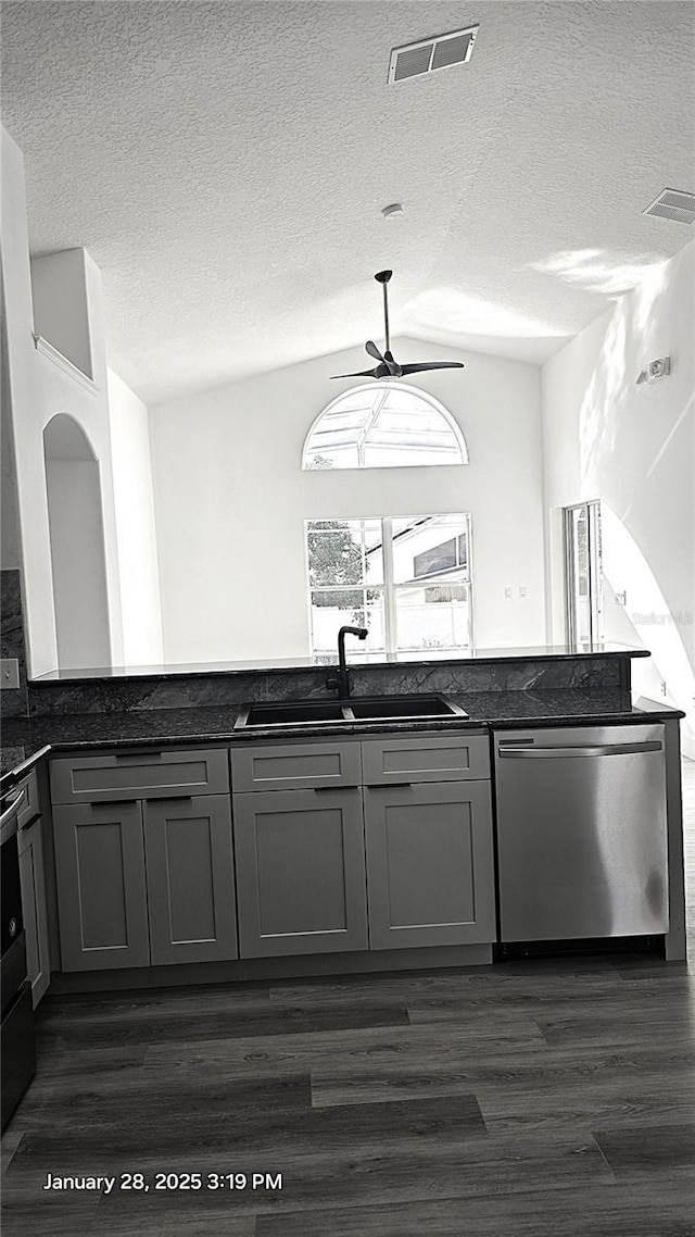 kitchen featuring sink, dishwasher, gray cabinetry, dark hardwood / wood-style floors, and vaulted ceiling