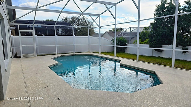 view of pool with a patio and glass enclosure