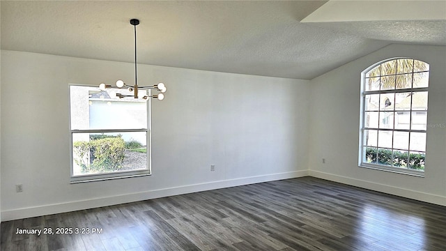 empty room featuring vaulted ceiling, dark wood-type flooring, a notable chandelier, and a textured ceiling