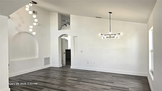 unfurnished room featuring dark hardwood / wood-style floors, high vaulted ceiling, and a notable chandelier