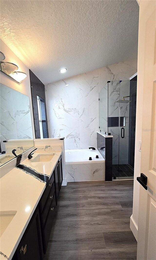 bathroom featuring vanity, wood-type flooring, independent shower and bath, and a textured ceiling