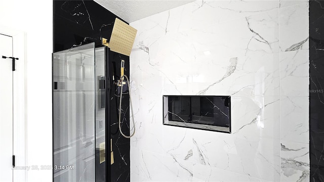 room details featuring a shower and a textured ceiling