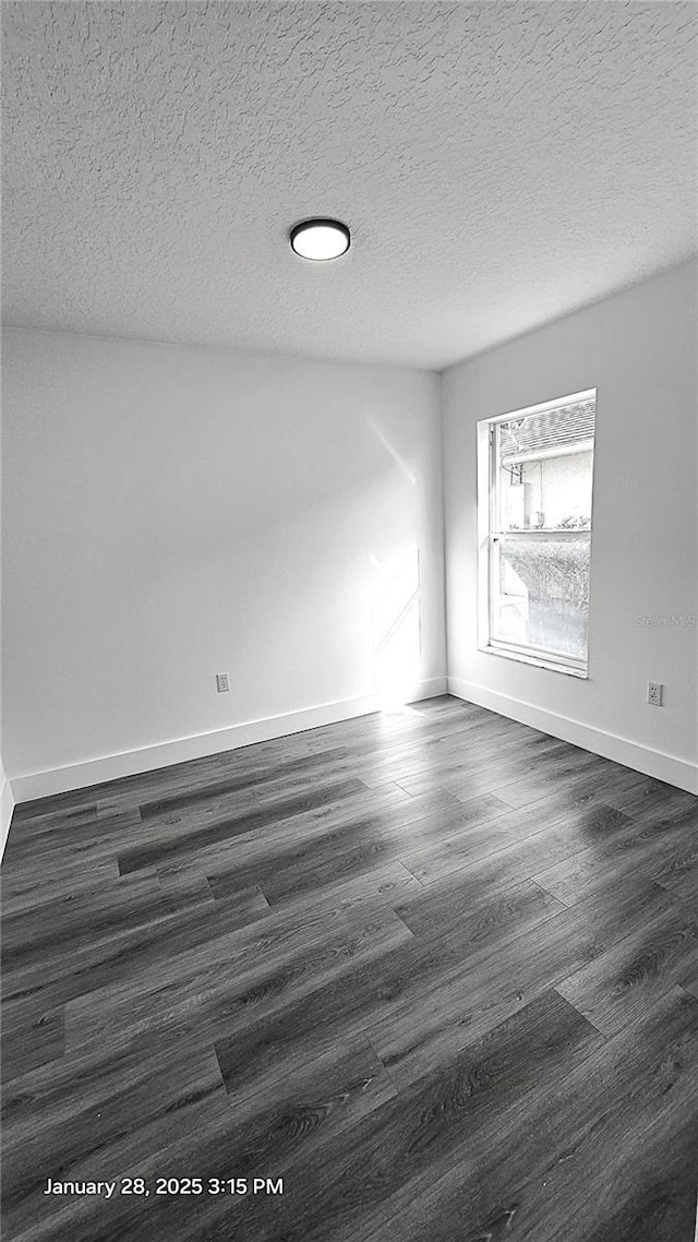 unfurnished room with dark wood-type flooring and a textured ceiling