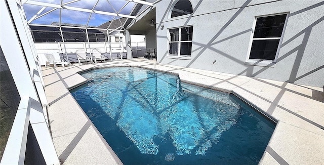 view of swimming pool featuring a lanai and a patio