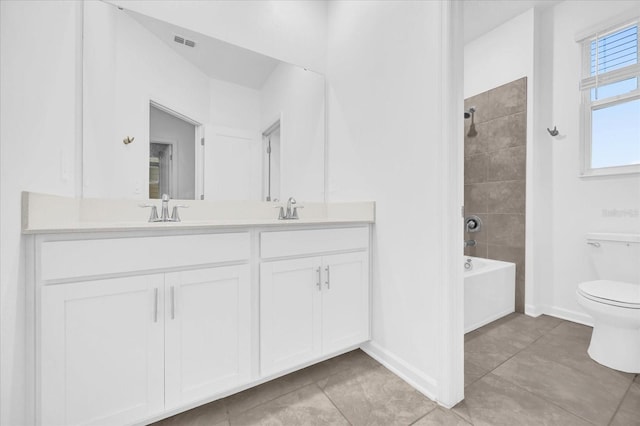 full bathroom featuring vanity, toilet, tiled shower / bath combo, and tile patterned flooring