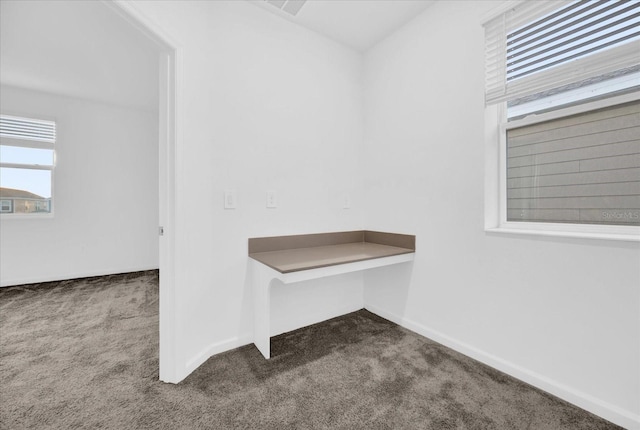 interior space with built in desk and carpet