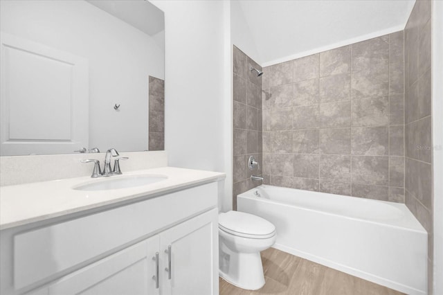 full bathroom featuring tiled shower / bath combo, wood-type flooring, vanity, and toilet