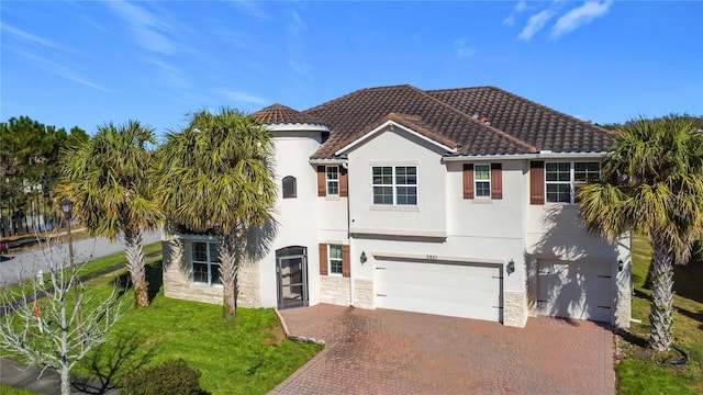 mediterranean / spanish-style home featuring a garage and a front yard