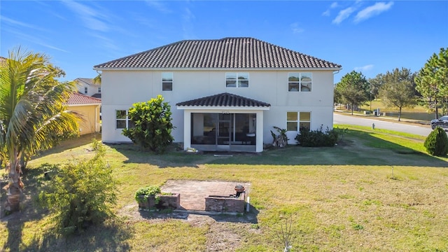 rear view of house featuring a yard and an outdoor fire pit