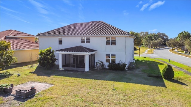 back of property with a yard and a sunroom