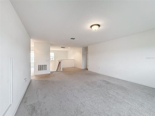 carpeted empty room with a textured ceiling