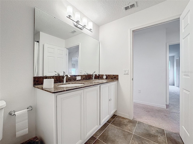 bathroom with vanity, tile patterned flooring, and a textured ceiling