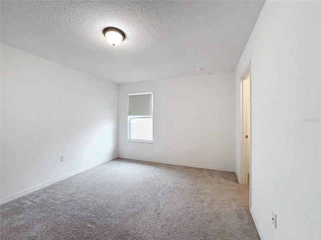 spare room featuring carpet and a textured ceiling