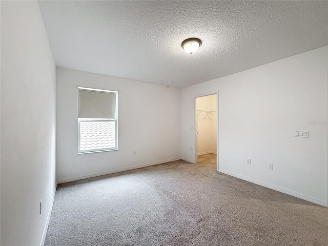 spare room with a textured ceiling and carpet