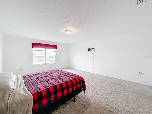 carpeted bedroom with a textured ceiling