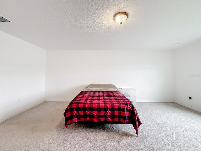 carpeted bedroom featuring a textured ceiling