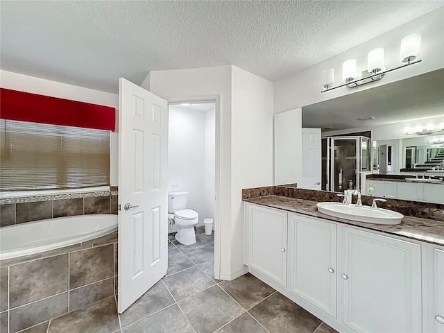 full bathroom featuring tile patterned floors, toilet, a textured ceiling, vanity, and plus walk in shower