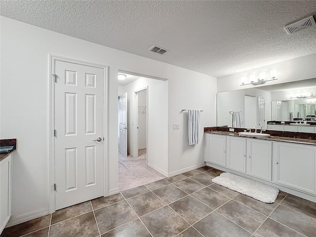 bathroom with vanity, tile patterned floors, and a textured ceiling