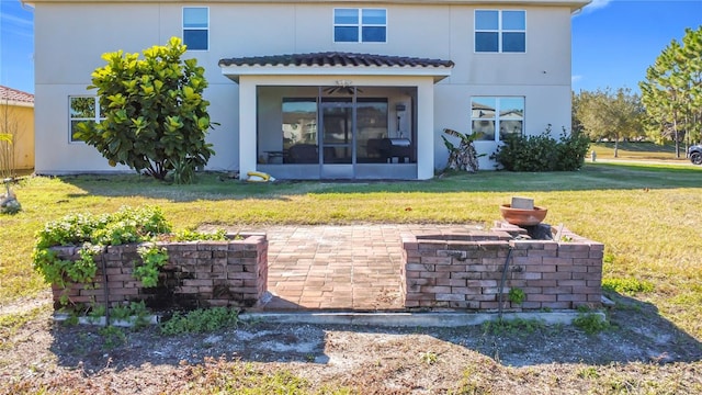 rear view of property featuring a sunroom, a patio, and a lawn