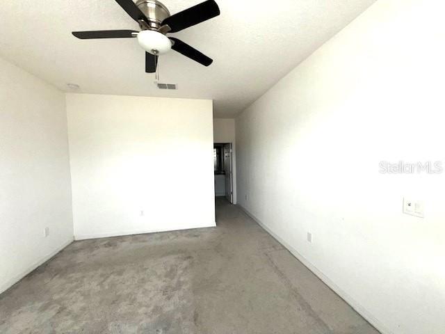 carpeted spare room with ceiling fan