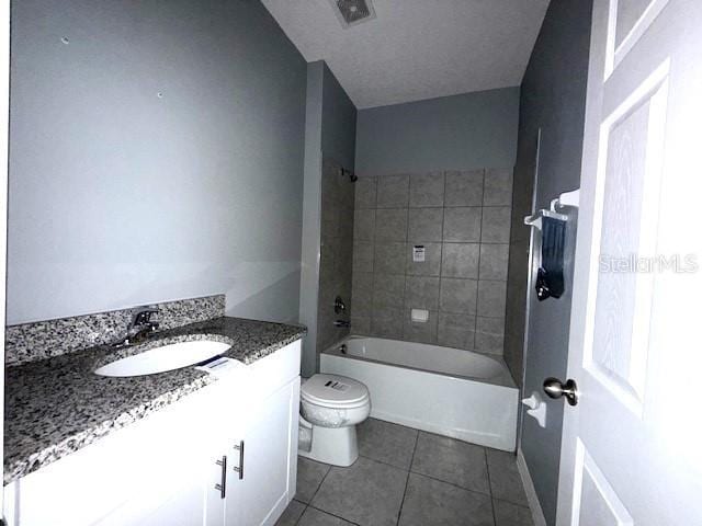 full bathroom featuring vanity, toilet, tile patterned floors, and tiled shower / bath