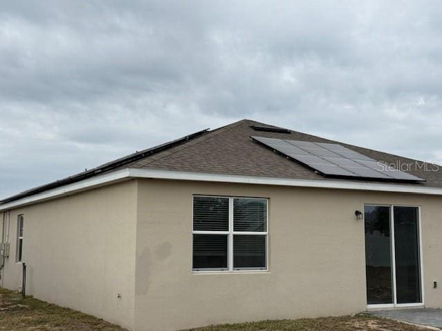 view of side of property featuring solar panels