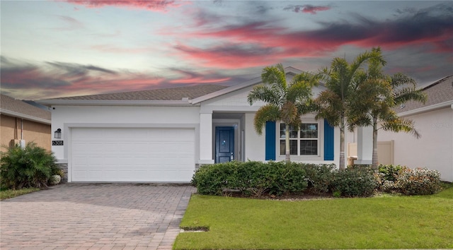 ranch-style home with a garage and a lawn