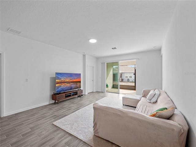 living room featuring a textured ceiling and light wood-type flooring