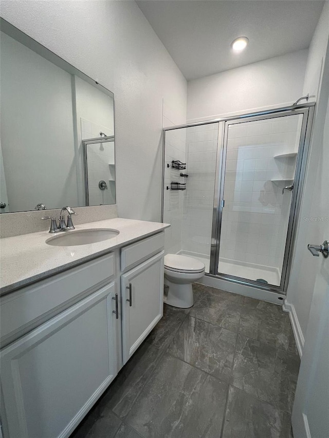 bathroom with walk in shower, vanity, and toilet