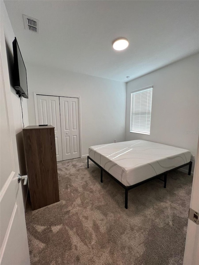 bedroom with dark carpet and a closet