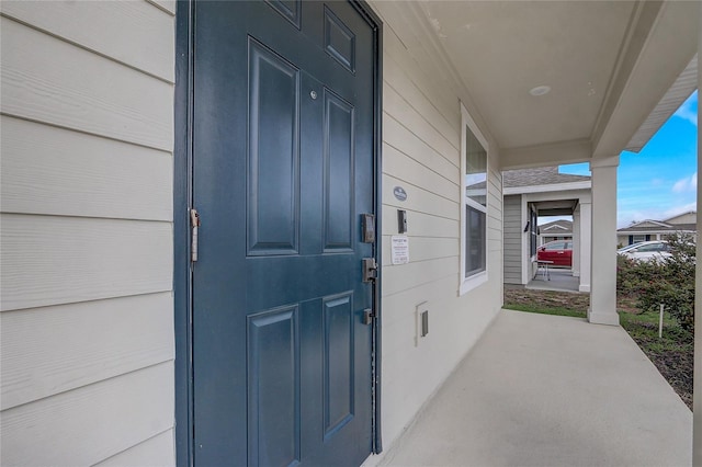 view of exterior entry featuring covered porch