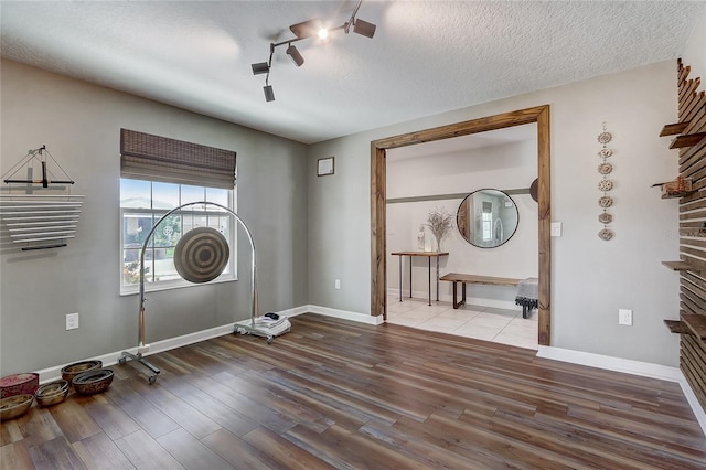 interior space featuring ceiling fan, wood-type flooring, and a textured ceiling