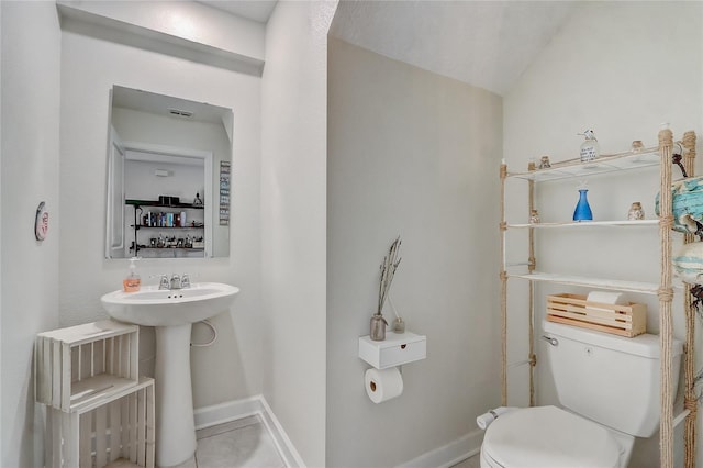 bathroom featuring toilet and vaulted ceiling