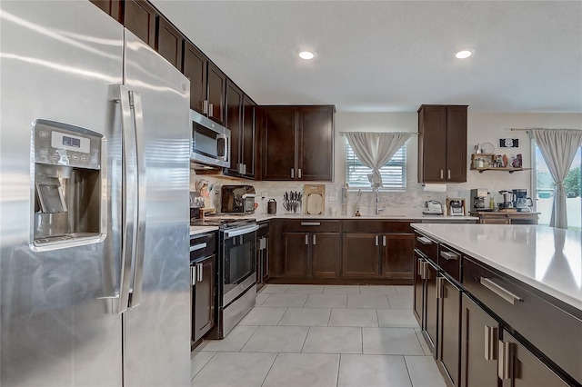 kitchen featuring appliances with stainless steel finishes, sink, backsplash, and plenty of natural light