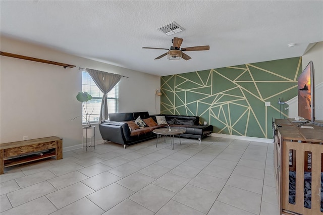 living room featuring ceiling fan, a textured ceiling, and light tile patterned floors