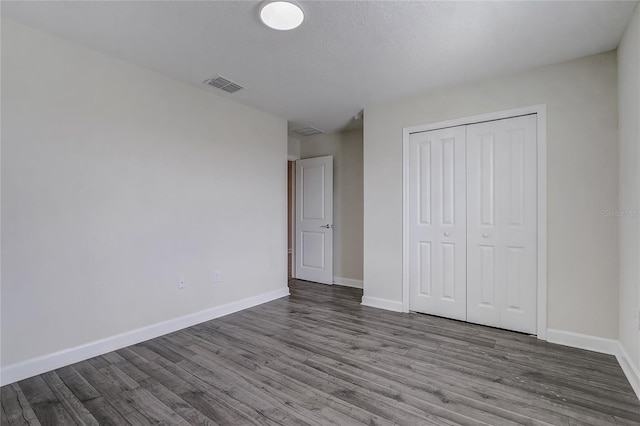 unfurnished bedroom with hardwood / wood-style flooring and a closet