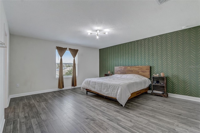 bedroom with a textured ceiling and light wood-type flooring