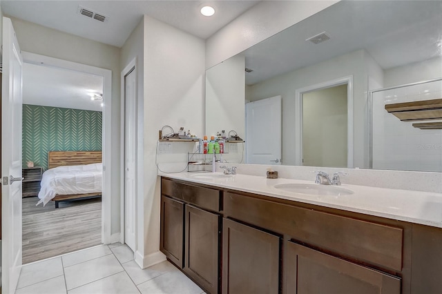 bathroom with walk in shower, tile patterned floors, and vanity