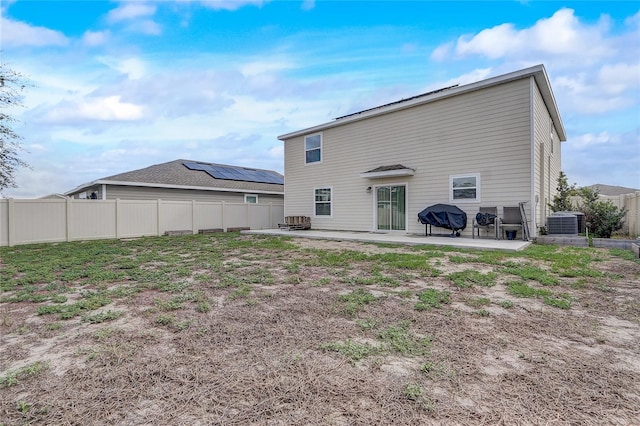 rear view of house featuring a patio, cooling unit, and a fire pit