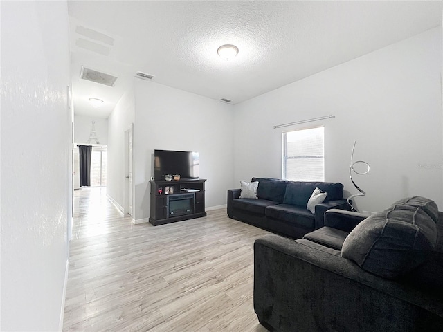 living room with light hardwood / wood-style floors and a textured ceiling