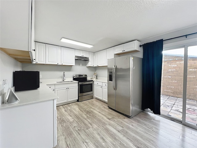 kitchen with white cabinetry, sink, light hardwood / wood-style flooring, and appliances with stainless steel finishes