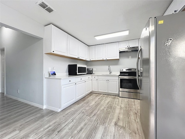 kitchen featuring sink, light wood-type flooring, white cabinets, and appliances with stainless steel finishes