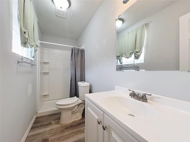 bathroom with vanity, curtained shower, wood-type flooring, and a textured ceiling