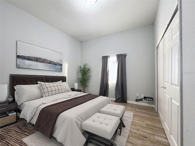 bedroom featuring a closet, a textured ceiling, and light hardwood / wood-style flooring