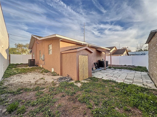 view of side of home with a patio and cooling unit