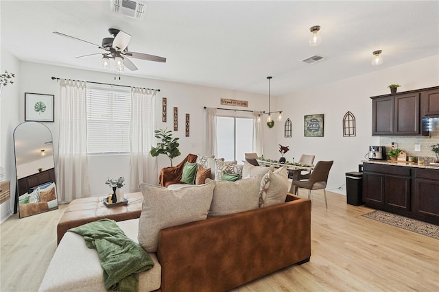 living room with ceiling fan and light wood-type flooring