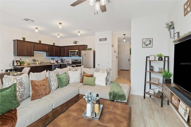 living room with ceiling fan and light wood-type flooring