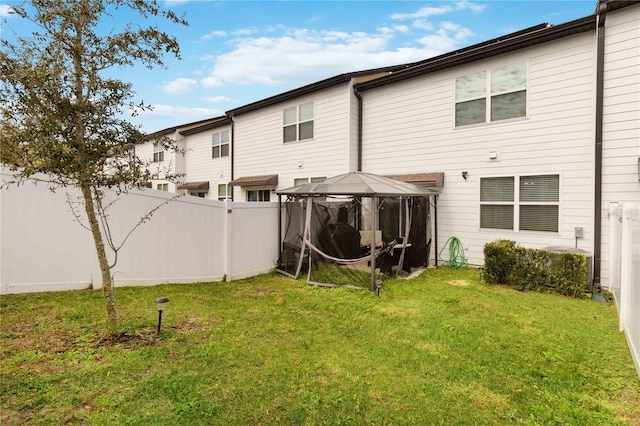 back of house with a yard and a gazebo