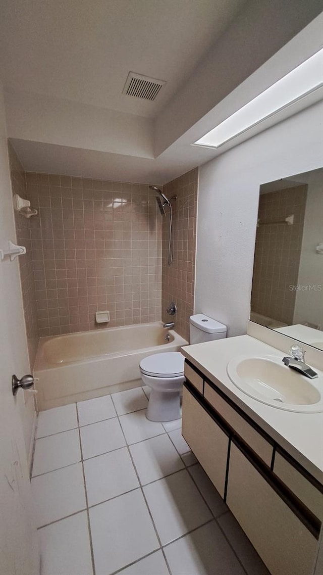 full bathroom with vanity, tile patterned flooring, toilet, and tiled shower / bath