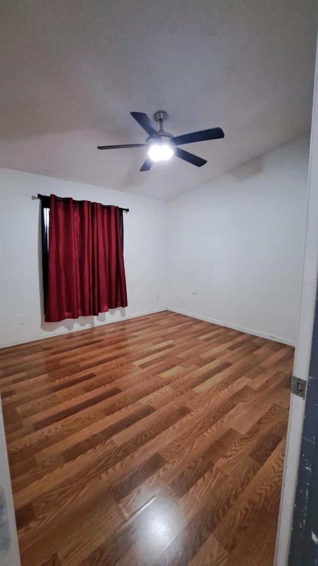 spare room featuring wood-type flooring and ceiling fan